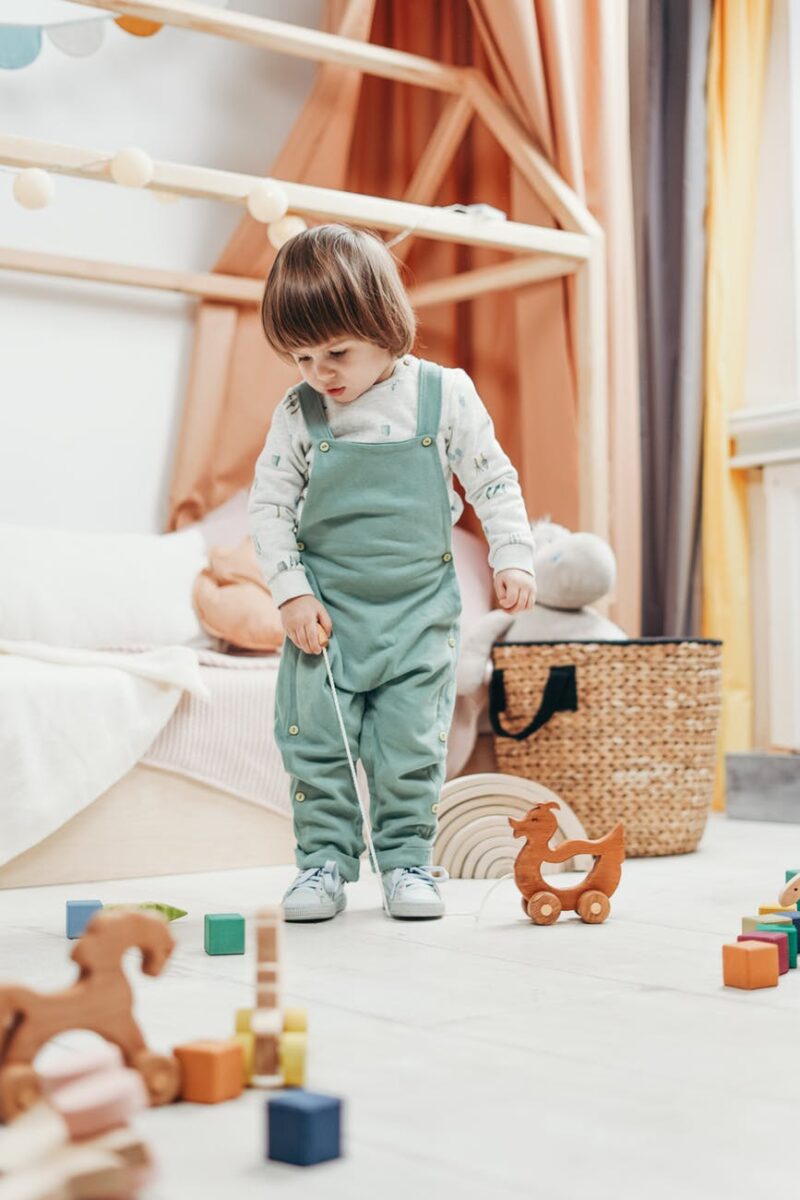 a child looking at the toys on the floor