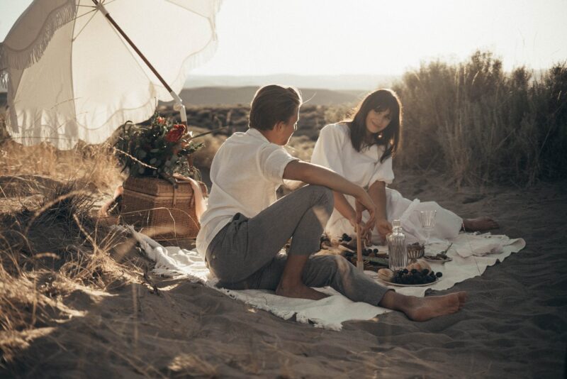 young couple having picnic on sandy beach